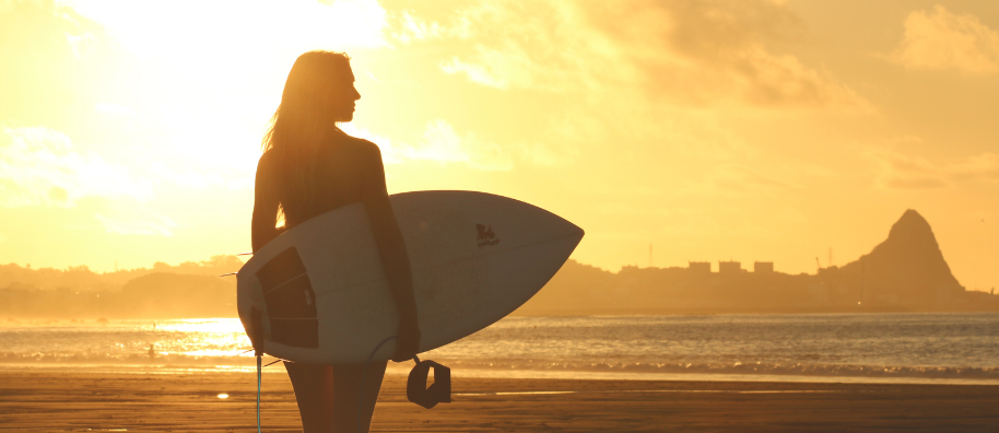 A person holding a surfboard looking out over the sea