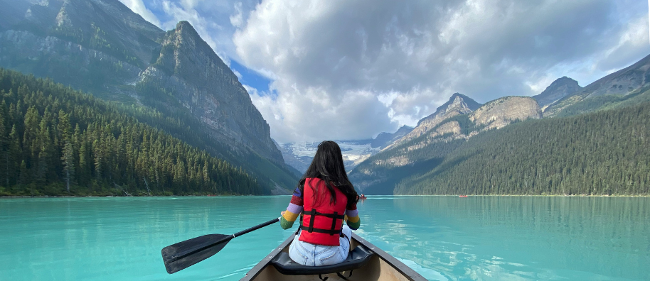A person on a canoe wearing a red life jacket